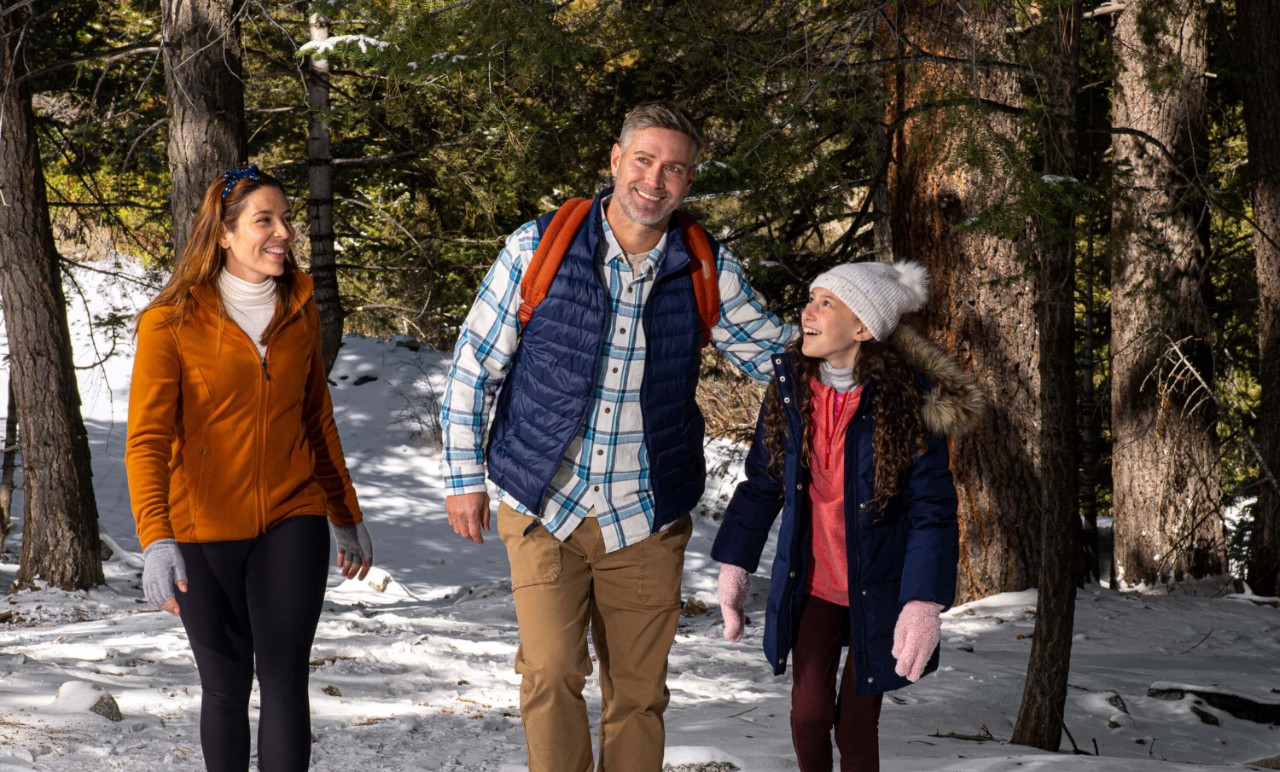 Woman, man, and child hiking in the woods