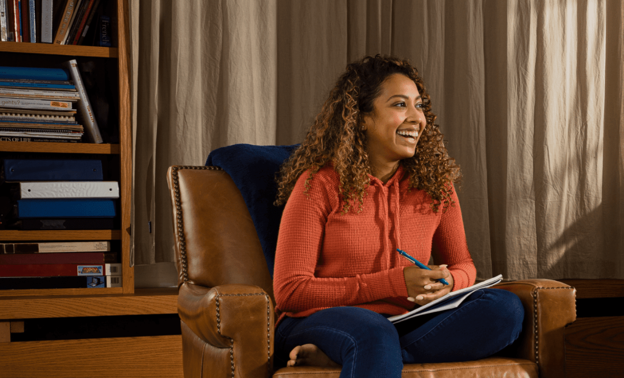 Woman sitting on chair and writing in a notebook